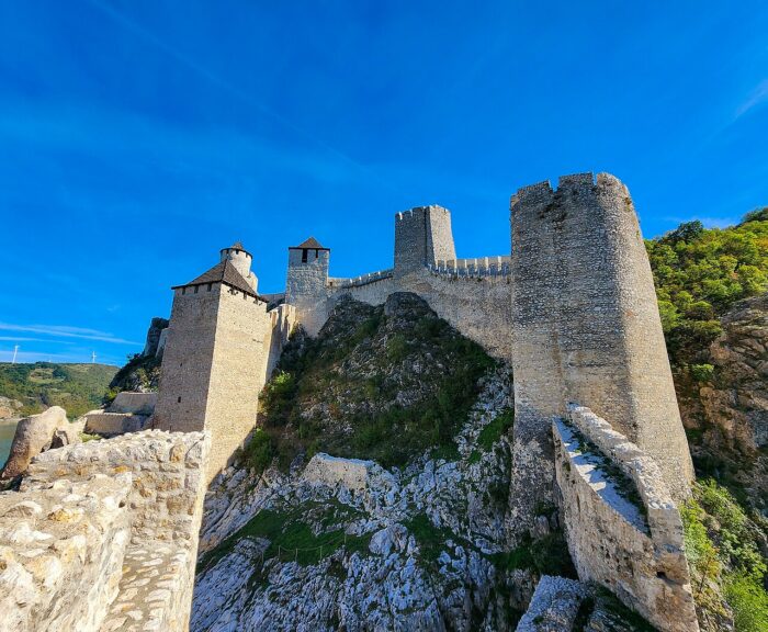 Stone towers and walls of Golubac Fortress beneath a blue sky in Serbia.