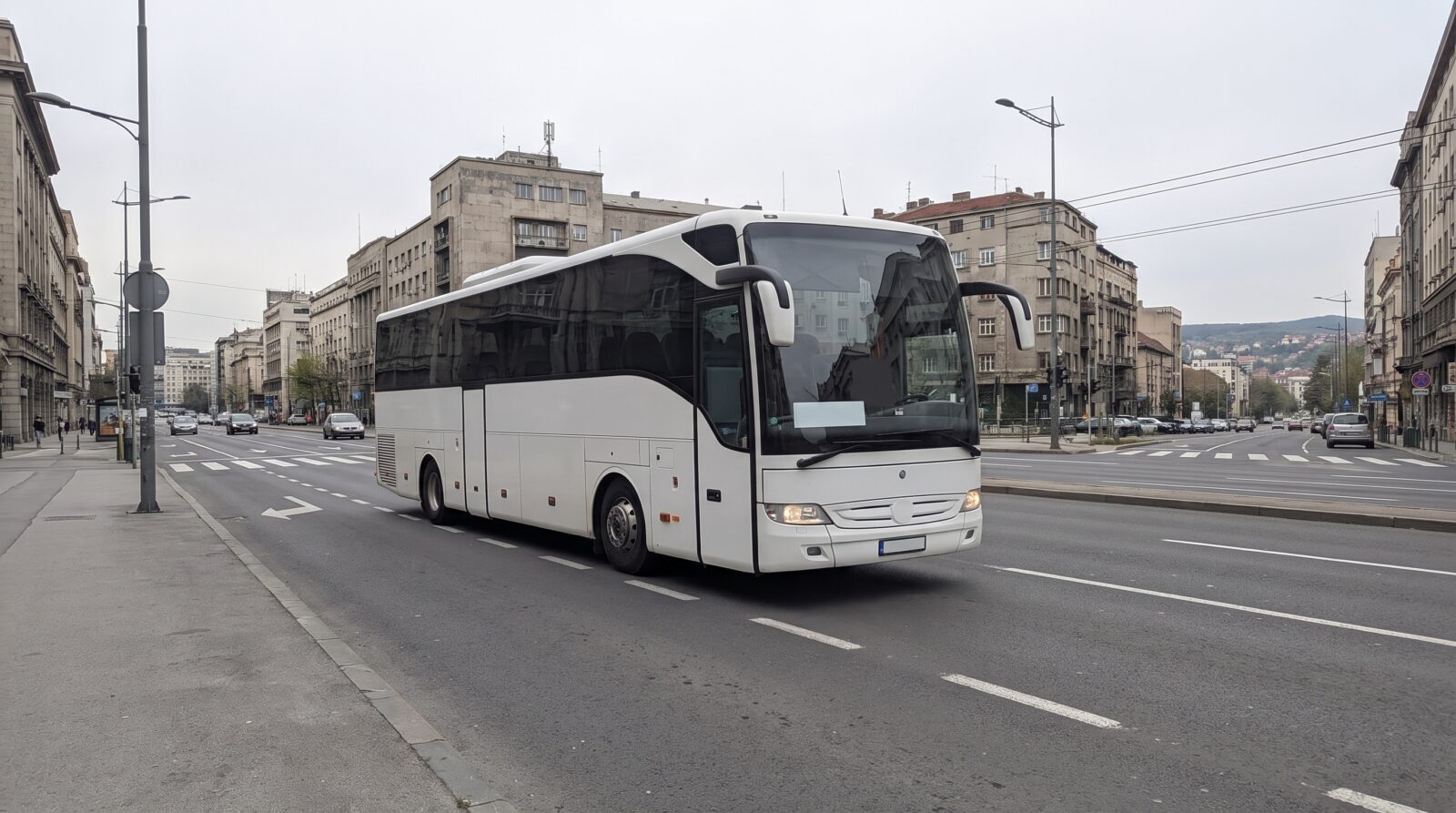 A public bus driving along a wide street in central Belgrade, with other traffic alongside