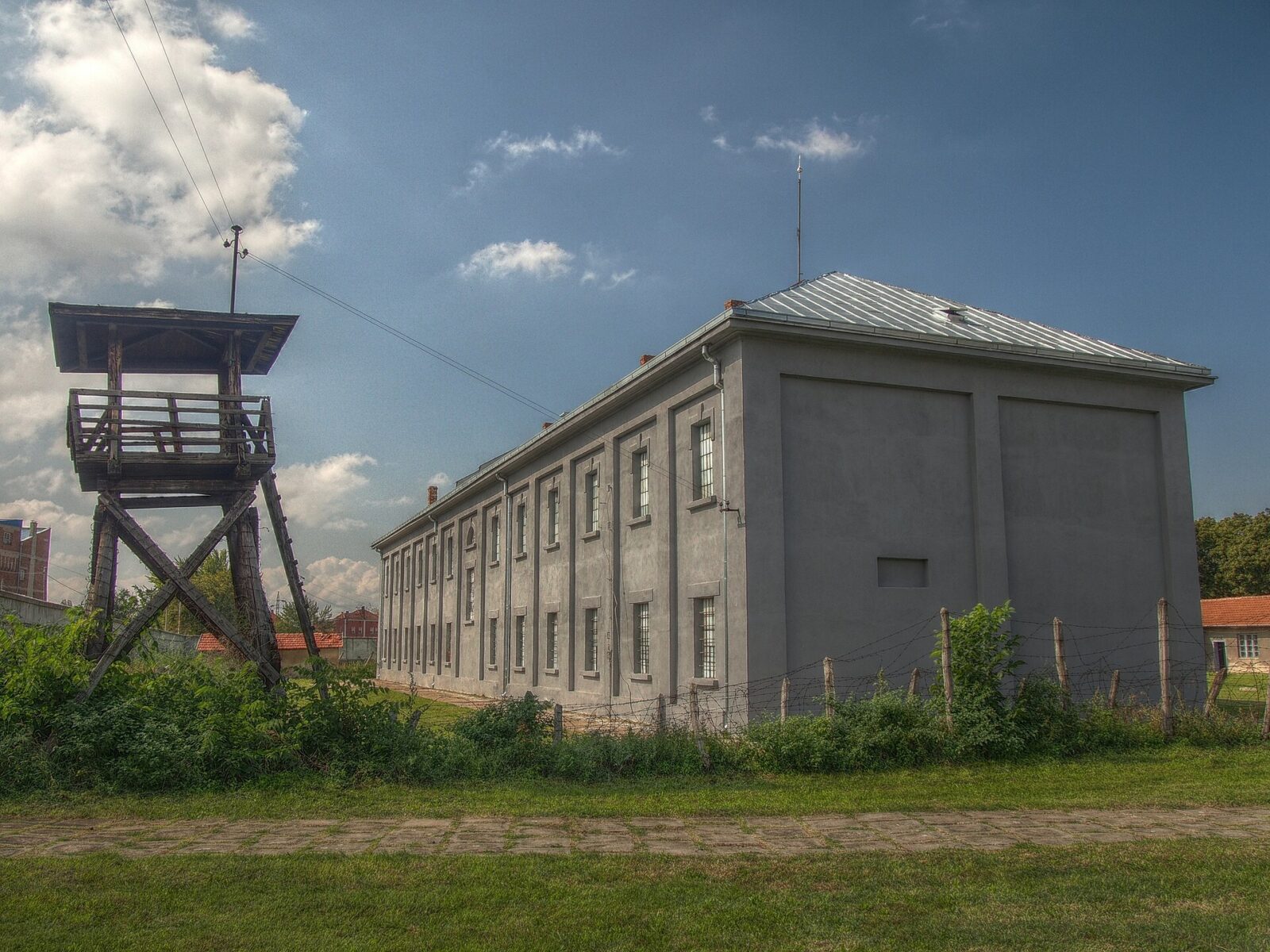 A reconstructed watchtower and the main building of the Crveni Krst camp memorial in Nis