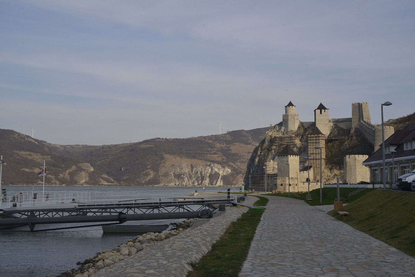 Stone towers of Golubac Fortress stepping up a steep hillside above the riverbank