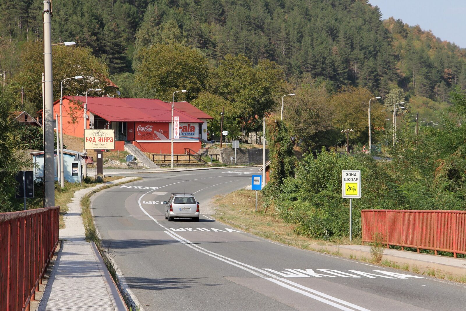 A small roadside settlement along the Ibar valley road, with a café and passing cars