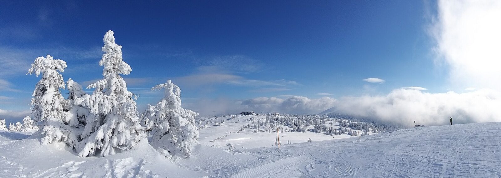 A wide snow-covered plateau within Kopaonik National Park, with distant peaks under a hazy sky