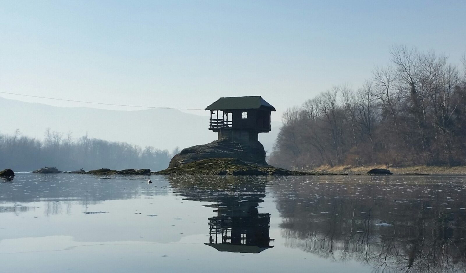 The small wooden house known as Kucica na Drini, perched on a rock in the middle of the Drina river