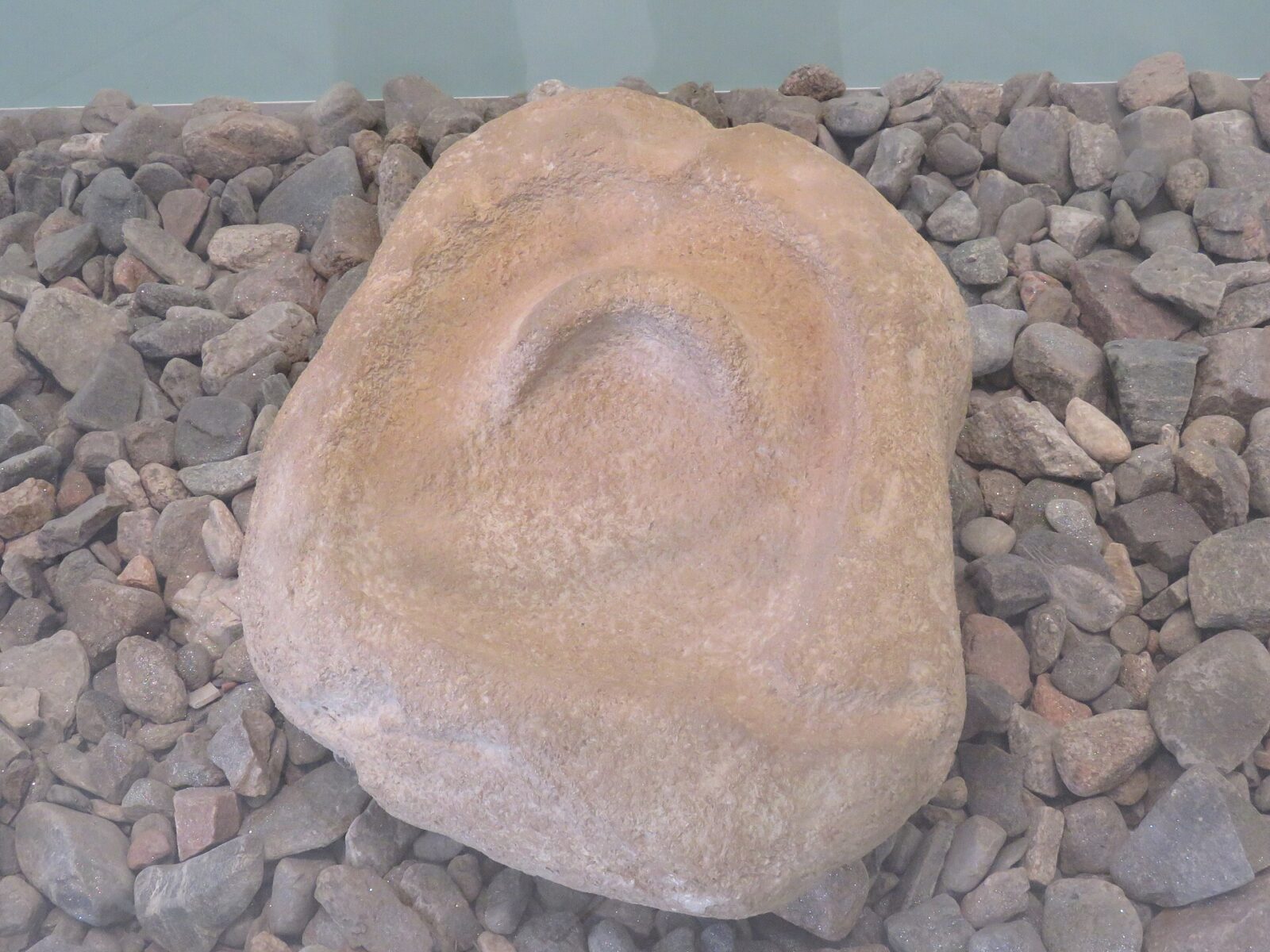 A carved sandstone boulder sculpture from Lepenski Vir, showing an ornamental motif