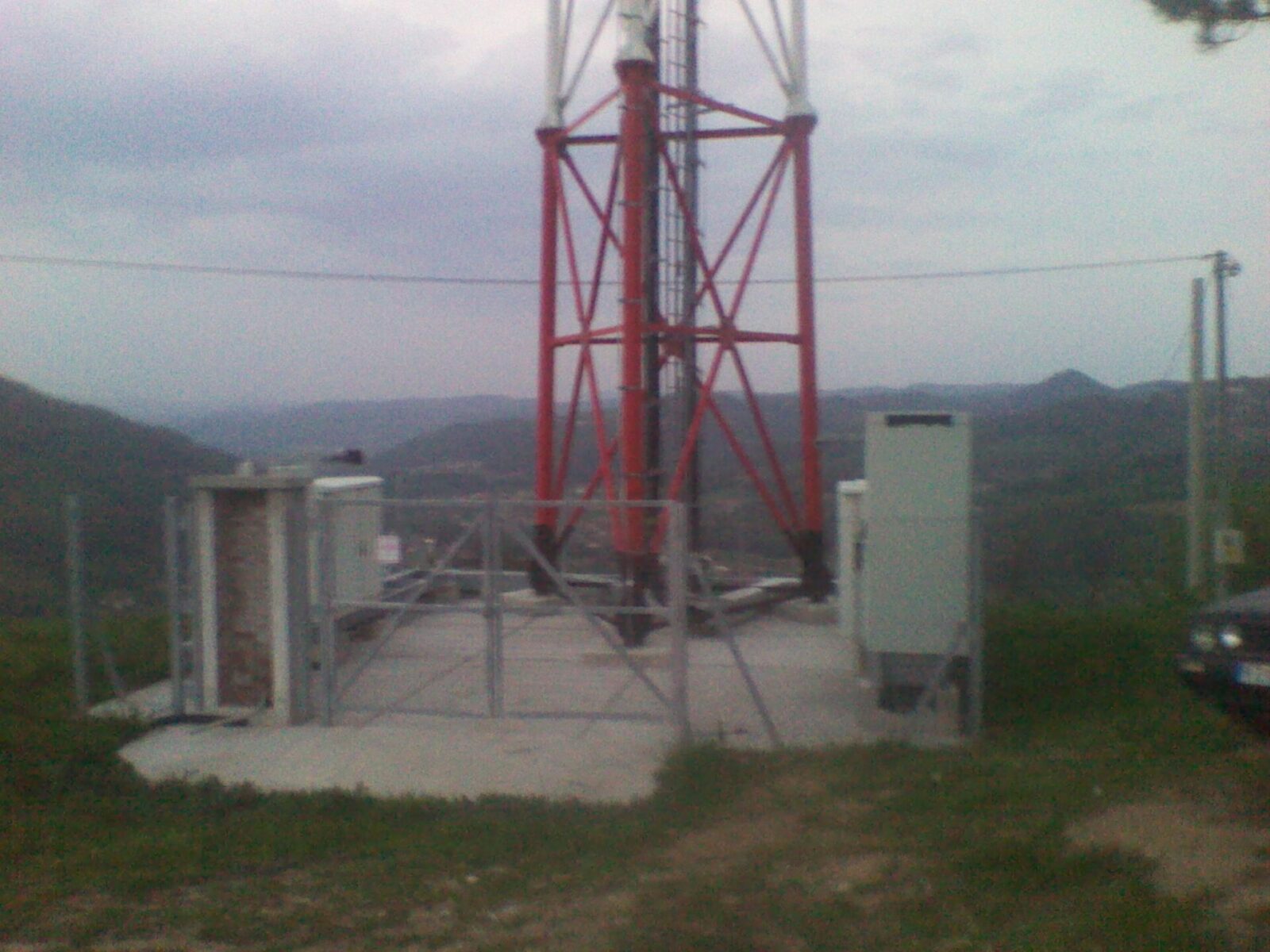 A mobile network relay mast rising above open countryside in Serbia