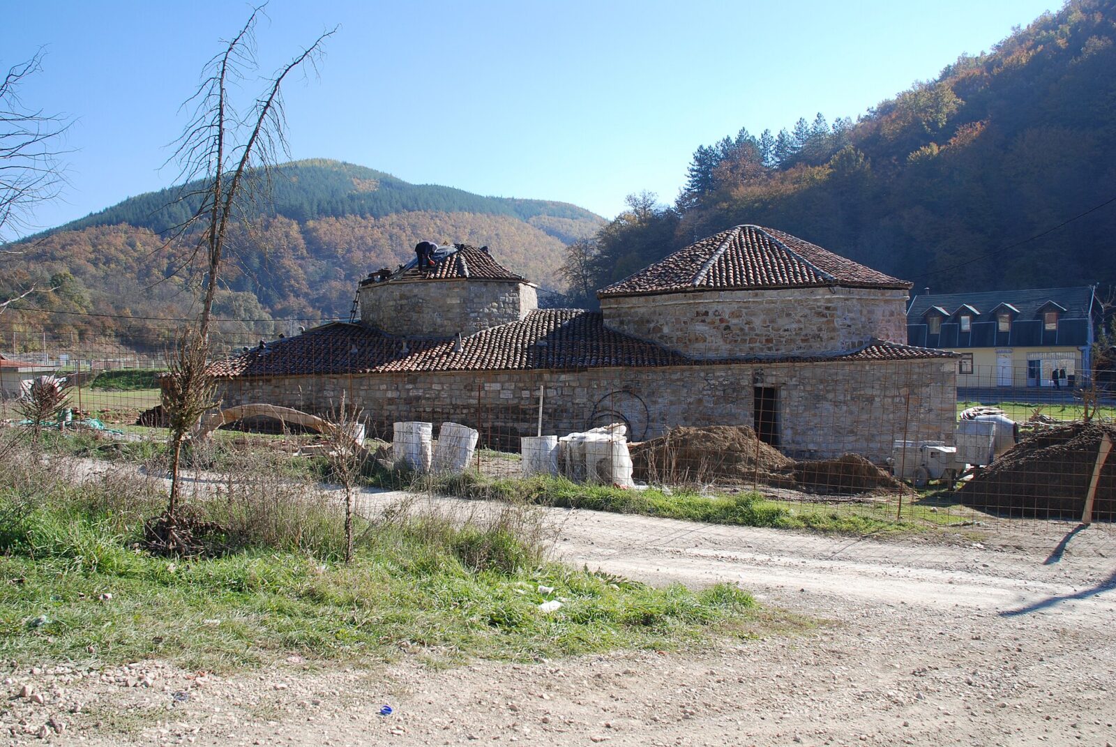 The domed stone buildings of the Old Novi Pazar Spa hamam, with hills in the background