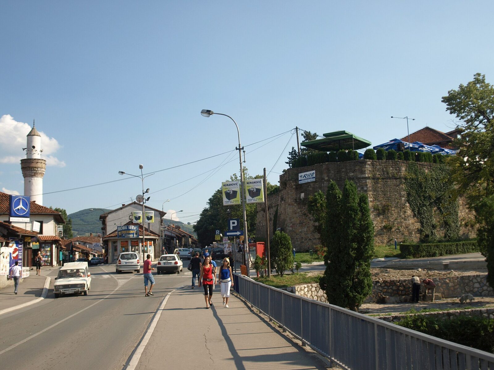 A street in Novi Pazar's old town, with a mosque minaret and the fortress wall in view