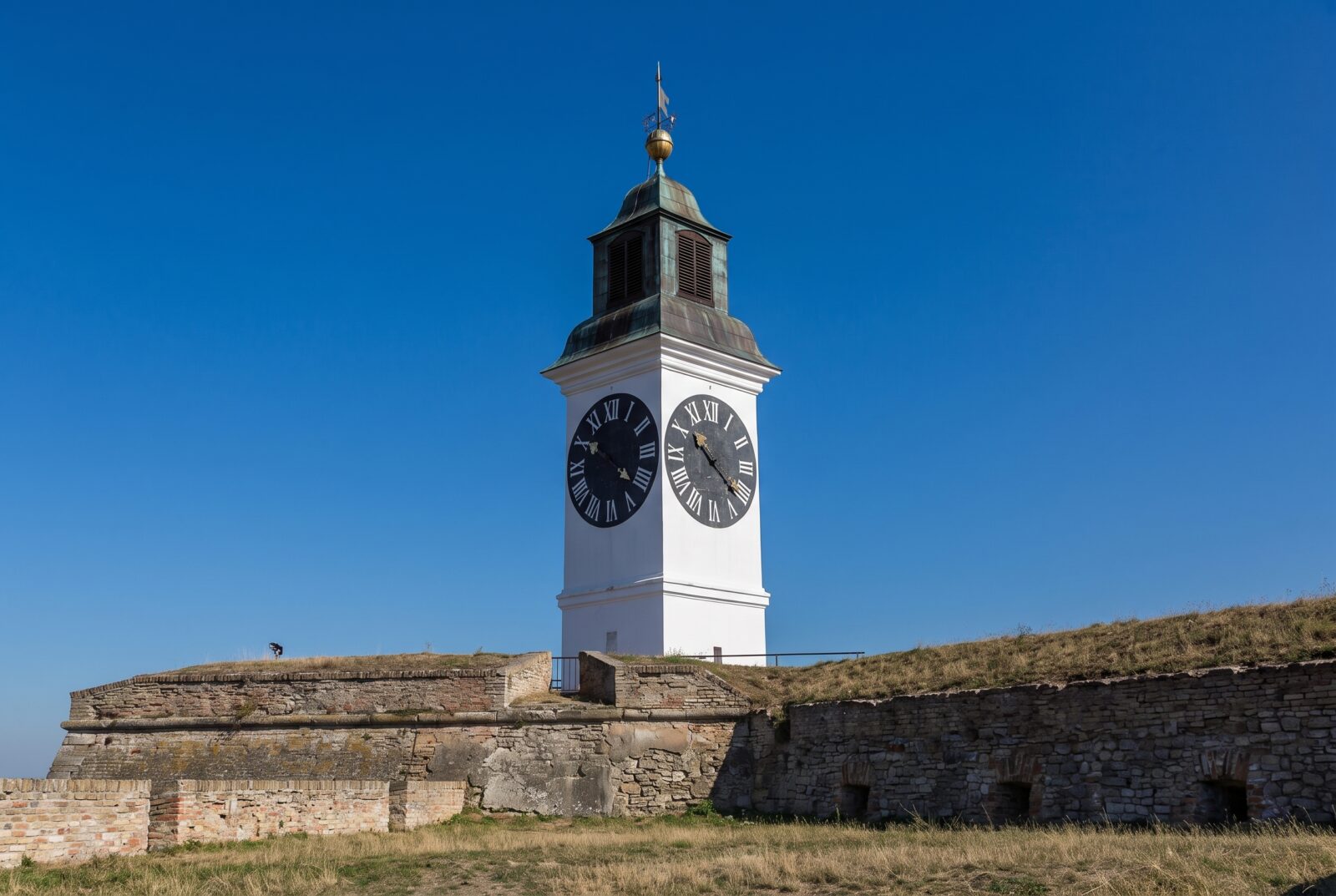 Close view of the Petrovaradin clock tower face, with its large hand marking the hour and small hand marking the minute