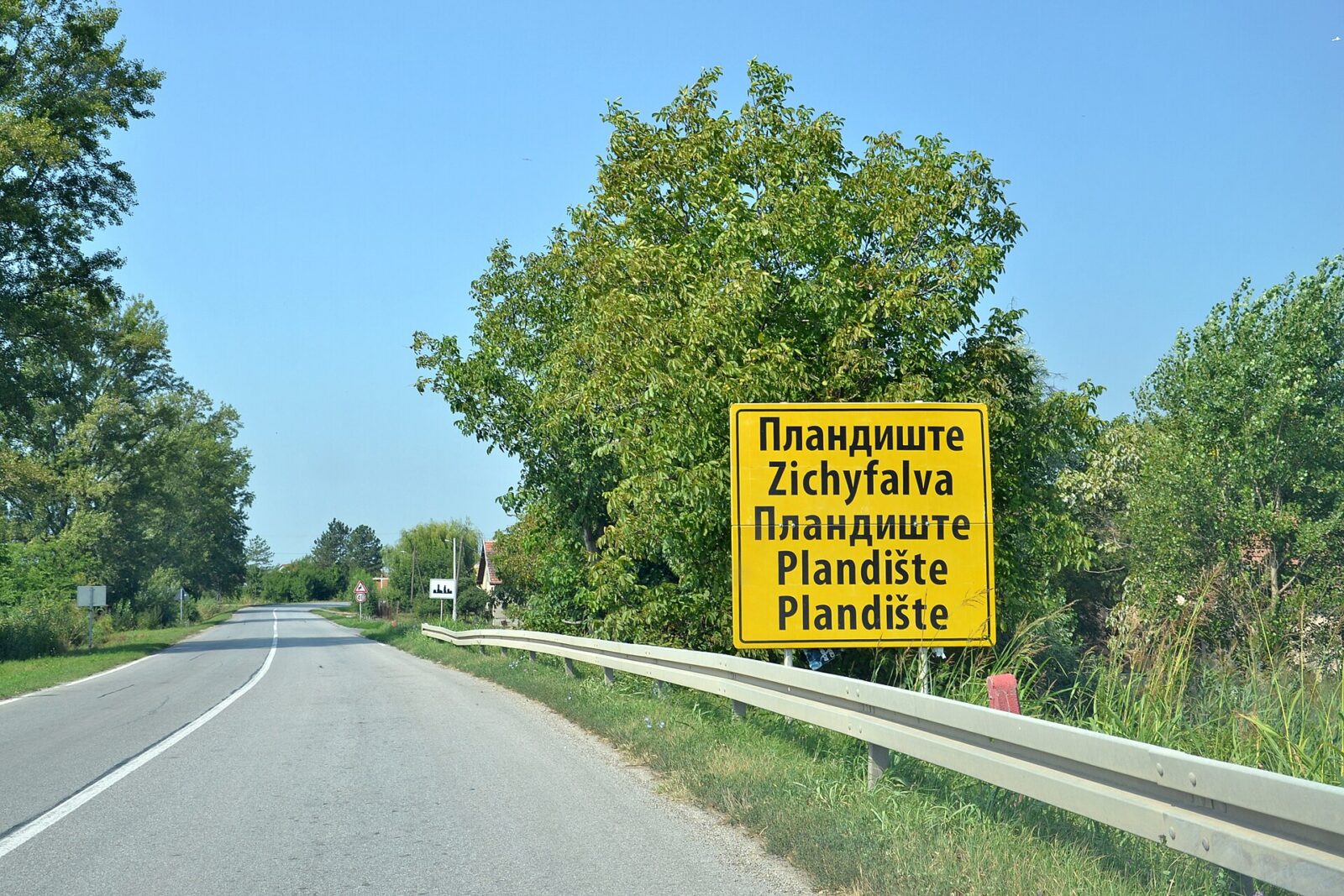 A multilingual city-limit sign in Vojvodina, showing the town's name in Serbian and a minority language