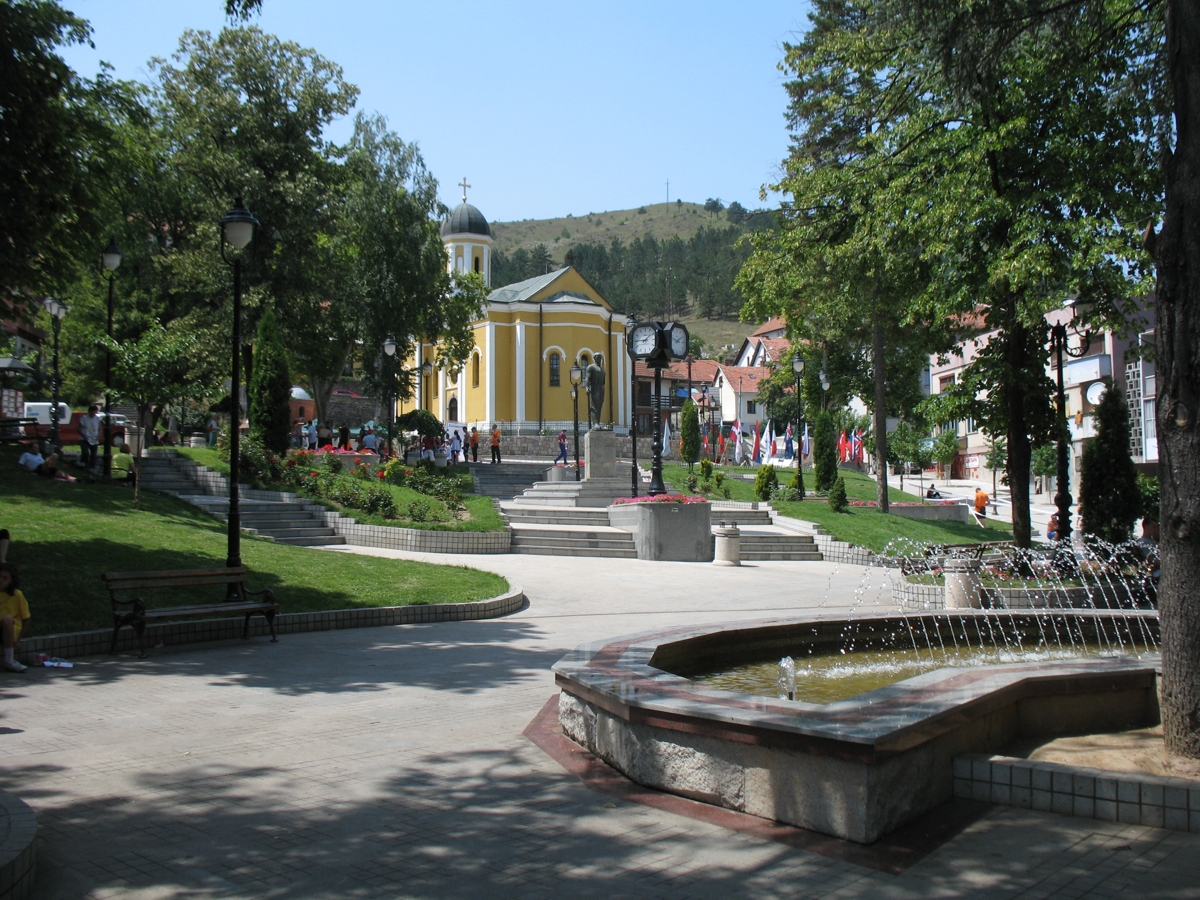 A tree-lined square in the centre of Raska, with a church and a fountain