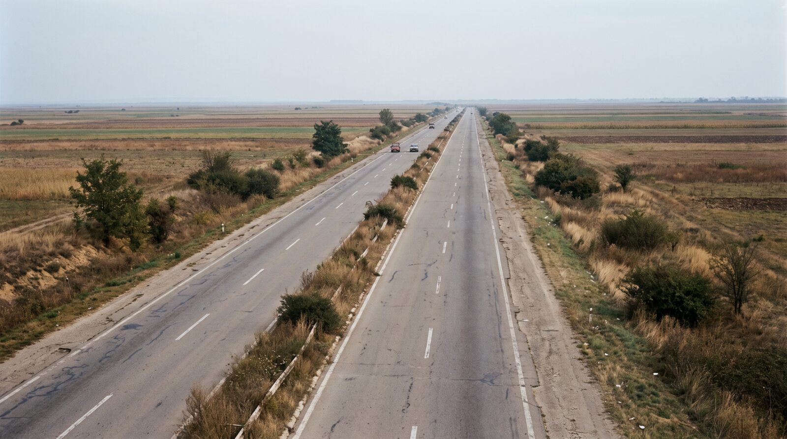 A motorway stretches through flat farmland toward a distant horizon
