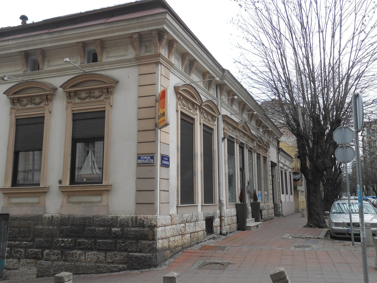 An ordinary Belgrade street corner with a Cyrillic street-name plate on the building