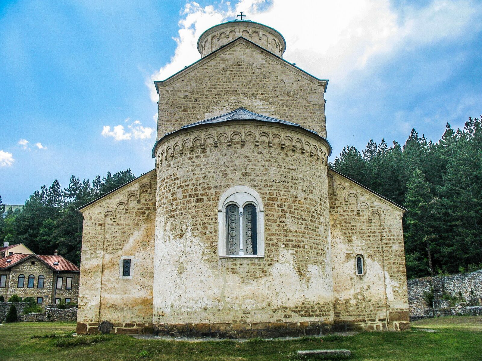 The stone apse of Sopocani monastery's church, with a small cross on its roof