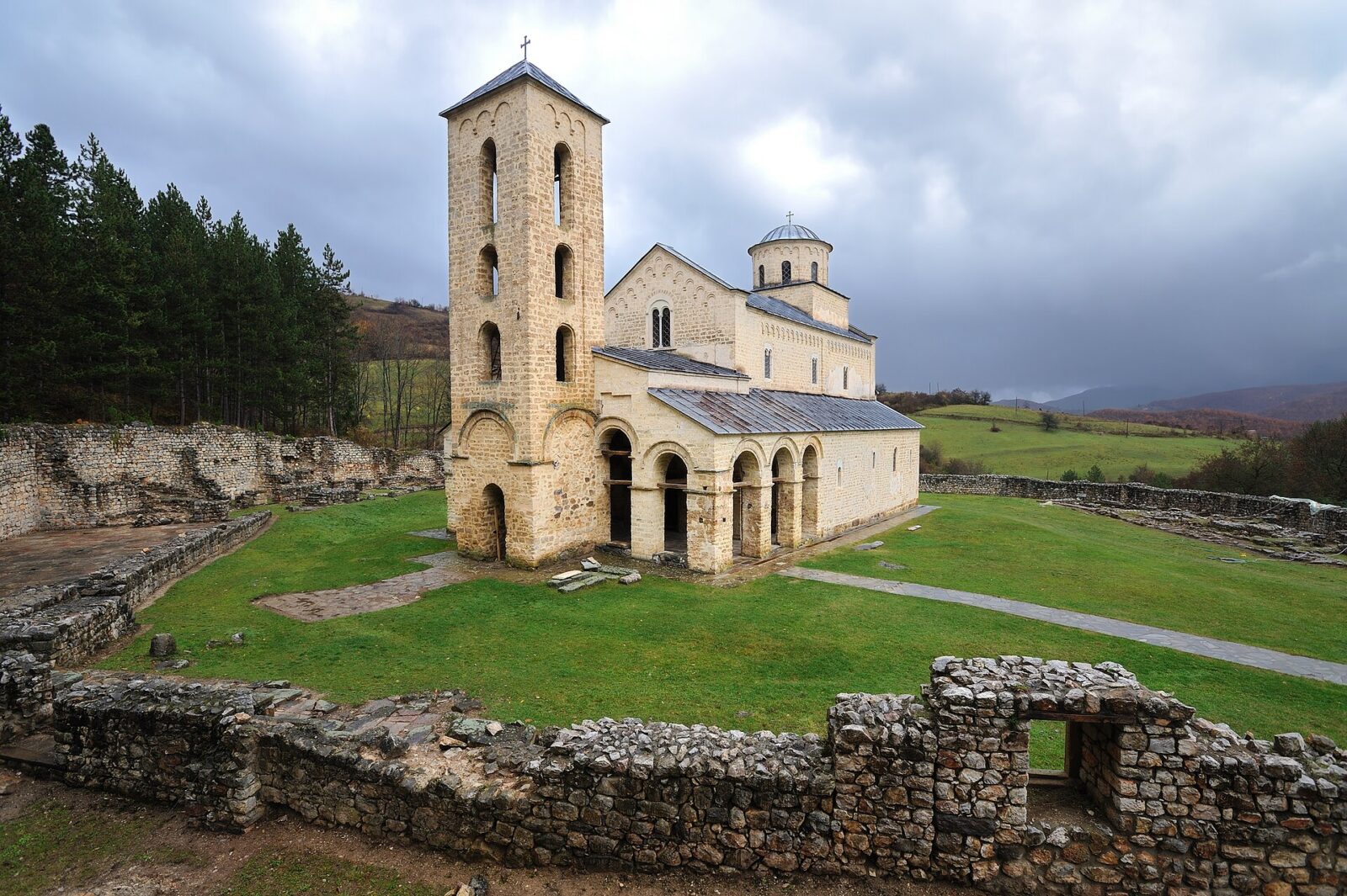 An elevated view of Sopocani monastery with stone wall ruins in the foreground