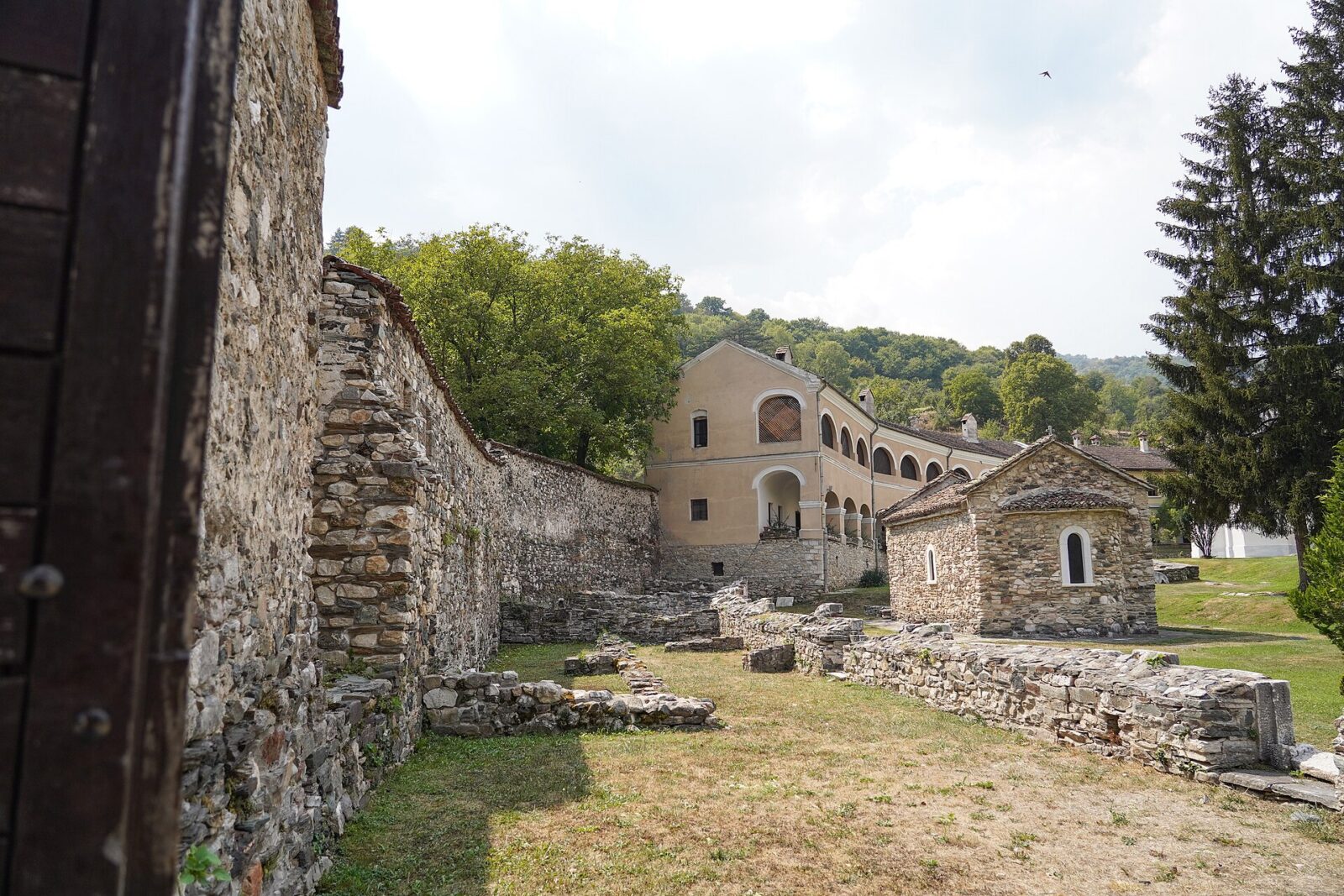 The stone perimeter wall of Studenica Monastery, with the guest house building beyond