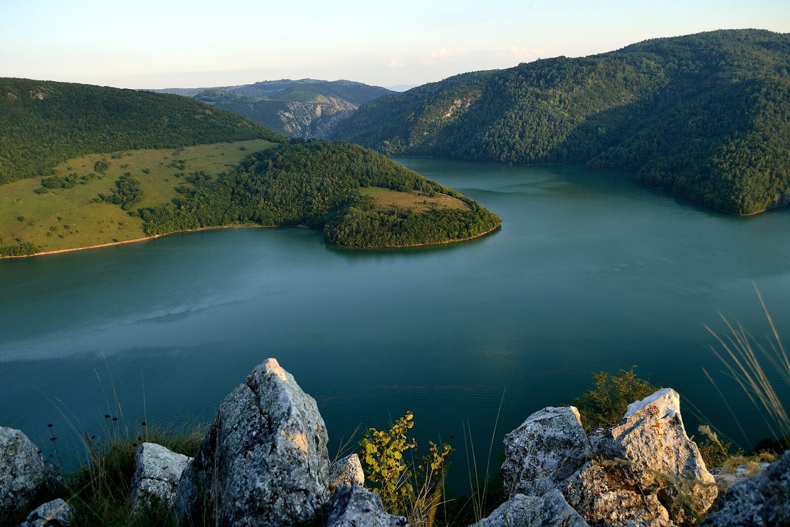 The green water of the Uvac lake framed by forested slopes