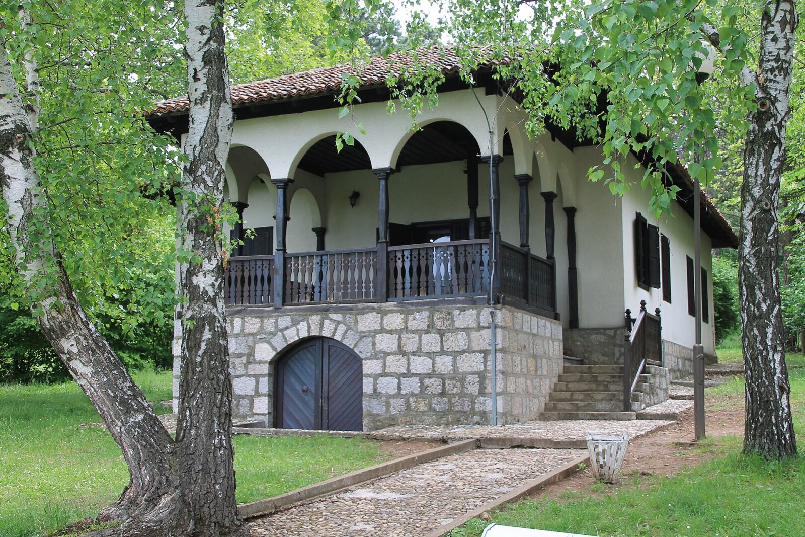 The Vineyard Keeper's House at Oplenac, with its stone base and arcaded porch